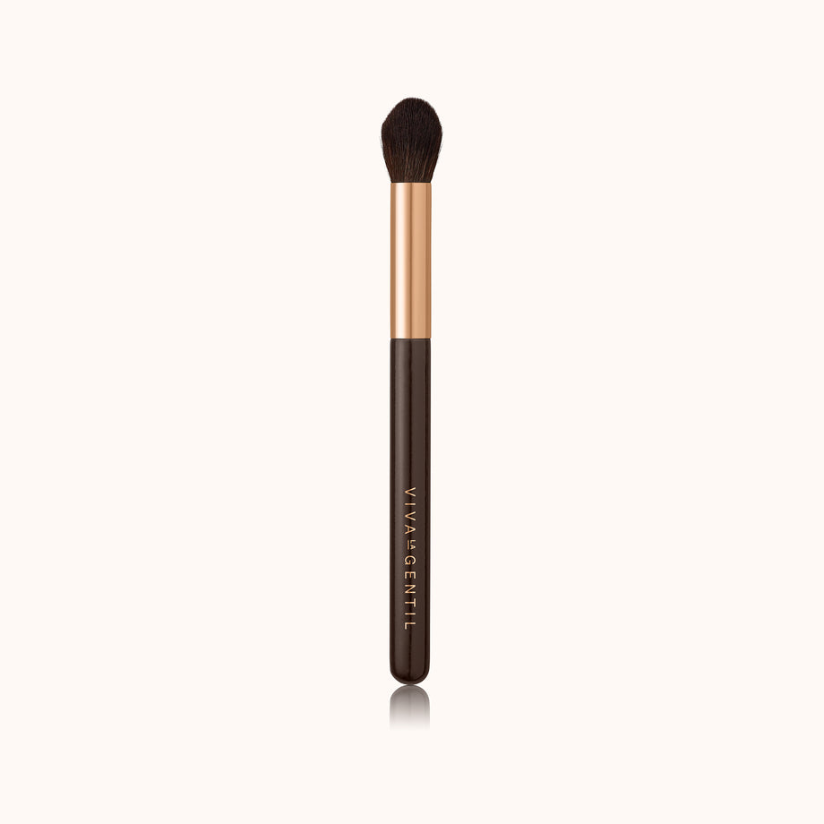 A precise tapered face and eye makeup brush with a dark brown lacquered handle and a rose gold ferrule, made by mixing handmade synthetic dark brown bristles with a few strands of white bristles.