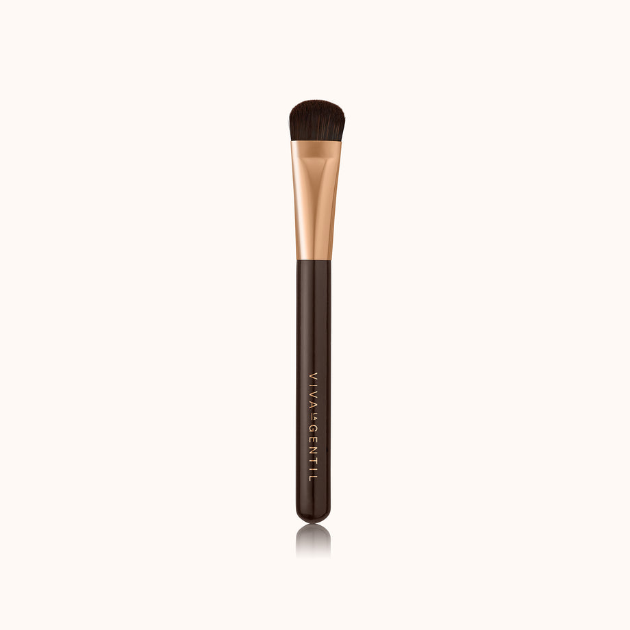 A soft curved thin makeup brush with a dark brown lacquered handle and a rose gold ferrule, made by mixing handmade synthetic dark brown bristles with a few strands of white bristles.